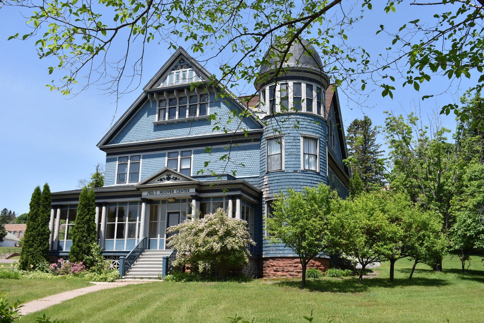 Queen Anne house, East Hancock MI | State Wide Real Estate of Houghton Blue Queen Anne house with corner turret and columned porch in East Hancock, Michigan