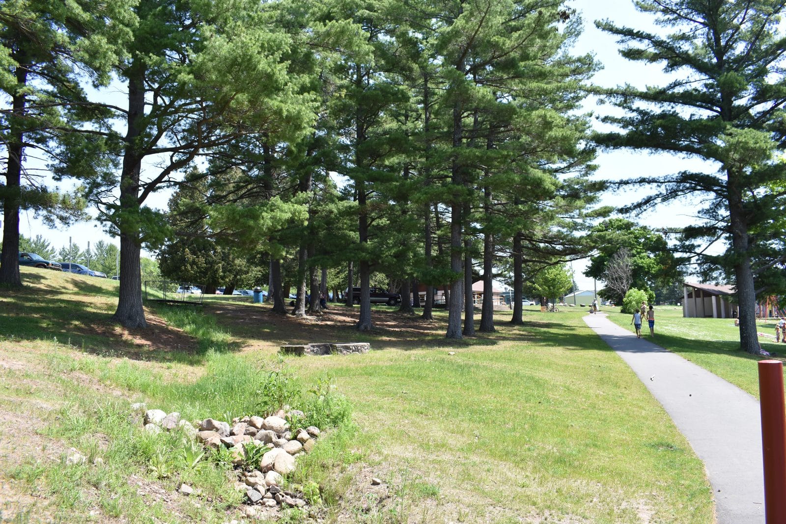 Hancock Recreation Area, Hancock MI | State Wide Real Estate of Houghton Paved walking path through tall pines at the Hancock Recreation Area on Portage Lake