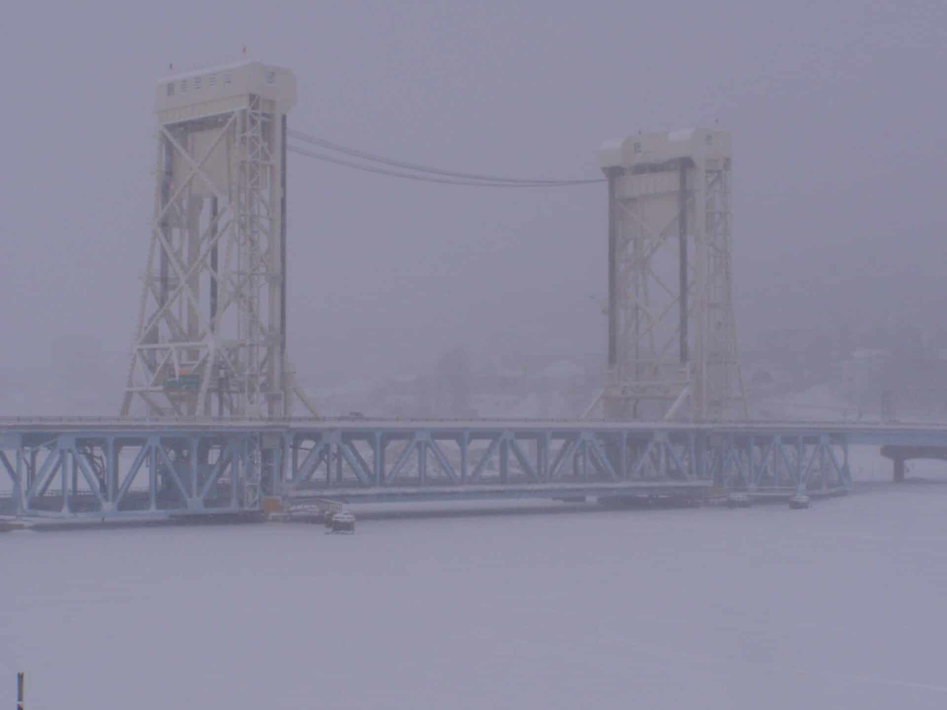 Lift bridge in winter, Hancock MI | State Wide Real Estate of Houghton The Portage Lake Lift Bridge over the frozen canal in falling snow