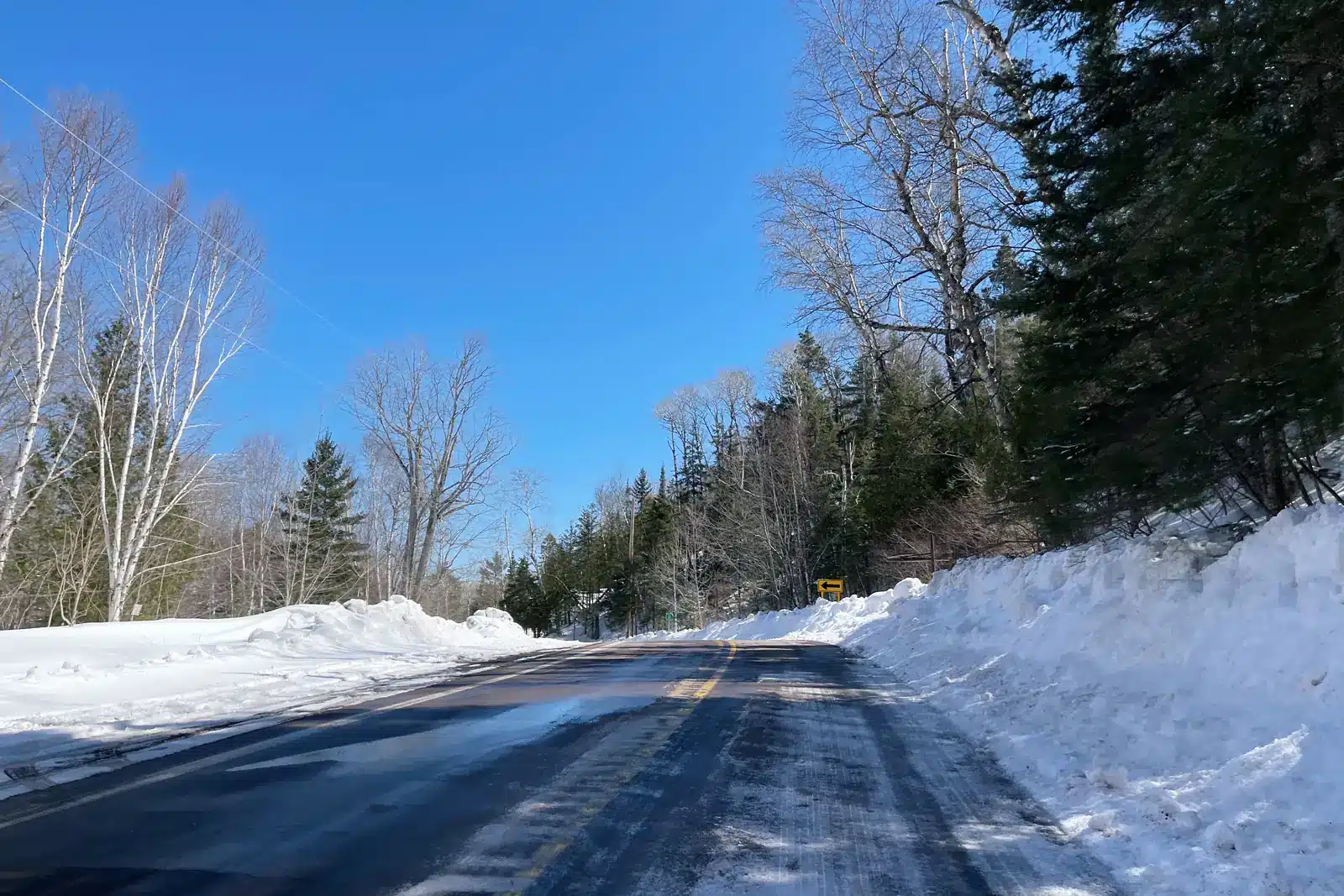 A plowed two-lane road between tall snowbanks in the Keweenaw.
