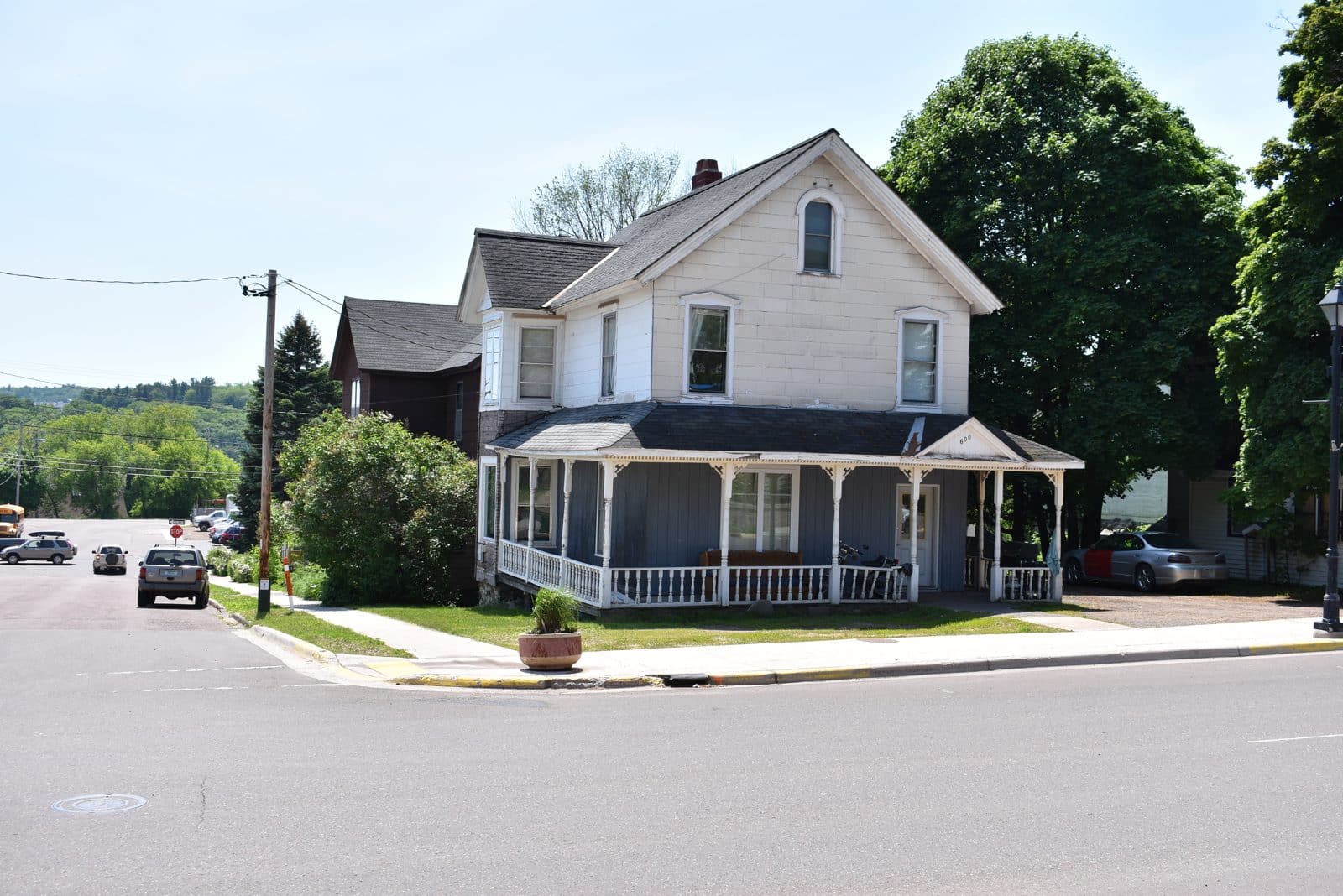 Victorian corner house, Hancock MI | State Wide Real Estate of Houghton White Victorian house with a wraparound porch on a corner lot in Hancock, Michigan