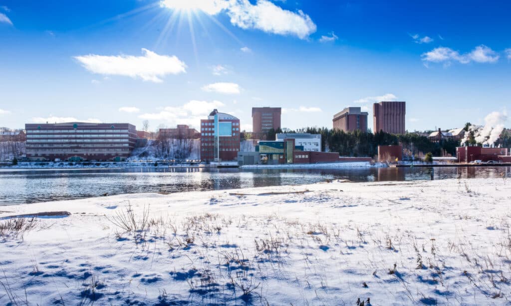 Michigan Technological University campus across the frozen Keweenaw Waterway on a clear winter day in Houghton, Michigan
