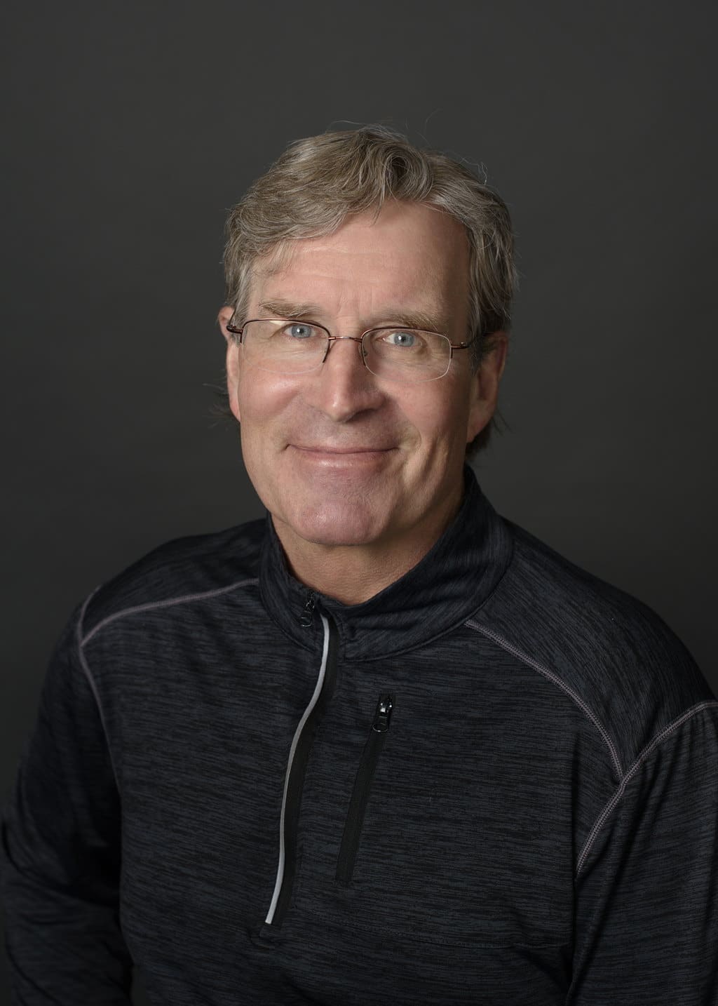 Steve Rowe, Sales Associate at State Wide Real Estate of Houghton, wearing a black quarter-zip pullover against a gray studio backdrop.